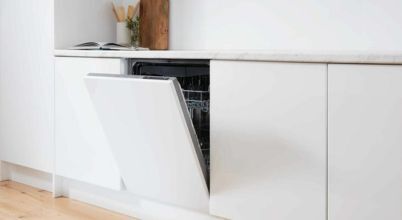 A fully integrated Euromaid brand dishwasher with a white front panel that matches the adjacent kitchen cabinetry.