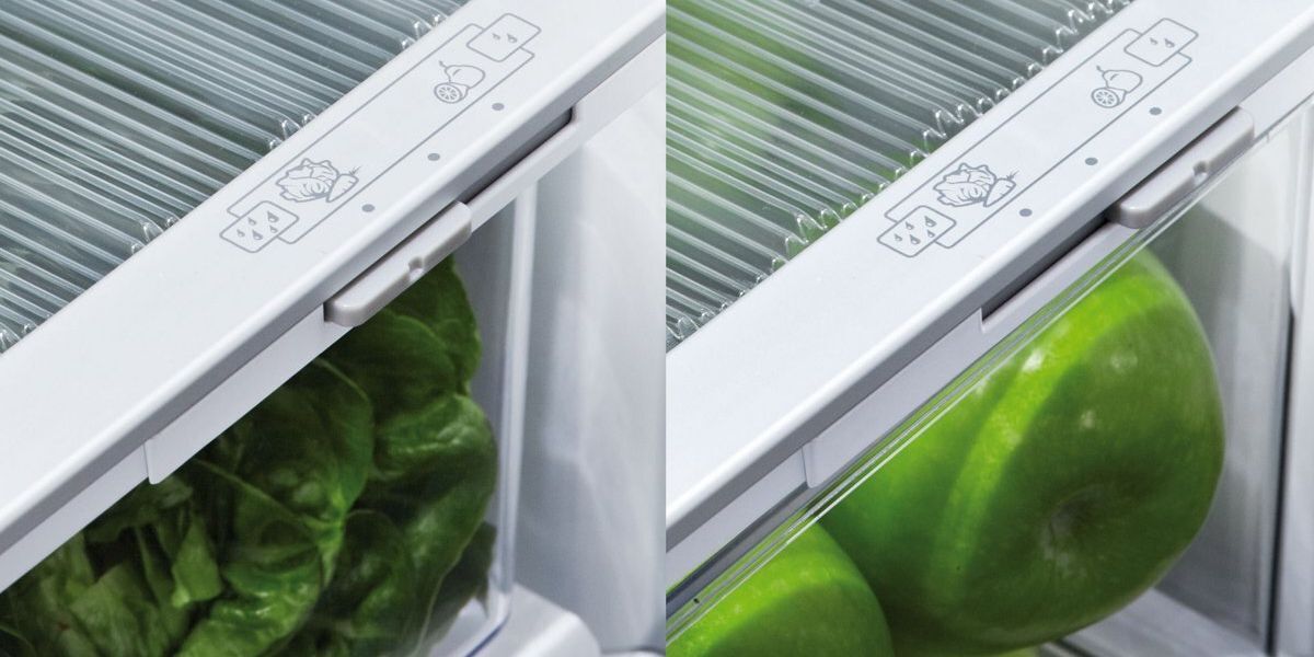 The crisper drawers in a Fisher and Paykel brand fridge, with air vent closed for higher humidity vegetable storage and open for lower humidity fruit storage.