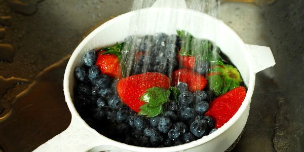 Washing strawberries and blueberries.